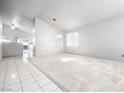Bright, open living room featuring neutral carpet, pendant lighting, and tiled entry at 3854 Spruceview Ct, Las Vegas, NV 89147