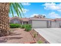 Charming single story home with desert landscaping, palm trees, and a two car garage at 4244 Totano Dr, North Las Vegas, NV 89032