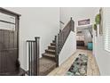 Welcoming entryway features coat rack, staircase with wood railing, decor, and wood flooring at 438 Shimmering Sands Ave, North Las Vegas, NV 89031