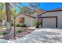 Single-story home with mature trees, desert landscaping, and a two-car garage at 4905 Ocean Shores Way, Las Vegas, NV 89130