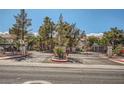 Gated community entrance with mature trees and well-manicured landscaping at 4955 Lindell Rd # 130, Las Vegas, NV 89118