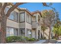 Exterior view of condo with multiple windows, a small balcony, and lush landscaping at 4955 Lindell Rd # 130, Las Vegas, NV 89118