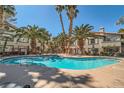 Resort-style community pool surrounded by palm trees, lounge chairs, and well-kept landscaping at 4955 Lindell Rd # 130, Las Vegas, NV 89118
