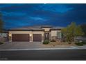 Well-maintained home featuring a three-car garage, desert landscaping, and a charming facade at dusk at 5234 Savannah Rose St, Las Vegas, NV 89149