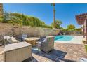 Outdoor living space featuring a refreshing pool, comfortable seating, and privacy wall at 5517 Bowerman Way, Las Vegas, NV 89130