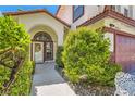 Landscaped walkway leads to a welcoming front door with an arched transom window at 5517 Bowerman Way, Las Vegas, NV 89130