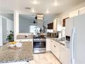 Modern kitchen with stainless steel appliances, granite countertops, and white cabinetry offering ample storage at 5929 Royal Castle Ln, Las Vegas, NV 89130