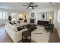Bright living room features a fireplace, neutral paint, ceiling fan, and tile flooring at 6134 Burleson Ranch Rd, Las Vegas, NV 89131