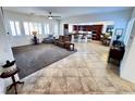 Open-concept layout with carpeted living room and tiled dining area and kitchen at 6134 Burleson Ranch Rd, Las Vegas, NV 89131