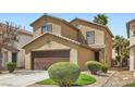 Well-manicured two-story house featuring a two-car garage and desert landscaping at 6390 Whispering Clouds Ct, Las Vegas, NV 89141