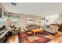 Bright living room featuring wood floors, couches and large area rug at 6390 Whispering Clouds Ct, Las Vegas, NV 89141
