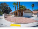 Landscaped front yard featuring palm trees and xeriscaping, paired with a charming home exterior at 684 Whispering Palms Dr, Las Vegas, NV 89123
