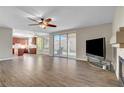 Open-concept living area showcases tile floors, fireplace, ceiling fan, and sliding glass doors to the patio at 7817 Safari Ln, Las Vegas, NV 89129