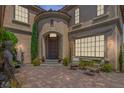 Elegant home entrance featuring a charming courtyard with outdoor seating and lush greenery at 7872 Regency Park St, Las Vegas, NV 89149