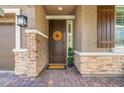 Inviting front entry with decorative wreath, stone accents and a charming welcome mat at 8058 Big Skye Ranch St, Las Vegas, NV 89166