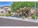 Two-story home with a two-car garage, a mature shade tree and manicured landscaping at 8091 Mosaic Sunrise Ln, Las Vegas, NV 89166