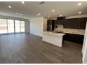Open-concept kitchen featuring stainless steel appliances, a center island, and sliding doors leading to the backyard at 84 Via Franello, Henderson, NV 89011
