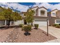 Inviting two-story home featuring a two-car garage, xeriscaping, and tasteful landscaping at 9740 Floweret Ave, Las Vegas, NV 89117