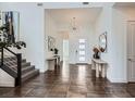 Bright foyer featuring tile flooring, a modern chandelier, and staircase with metal railing at 10748 Steel Ridge Ct, Las Vegas, NV 89135