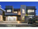 Modern home showcasing stylish garage, sleek architecture, and illuminated exterior at 1181 Calle De Luz, Henderson, NV 89012