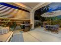 Outdoor patio with grill, dining table, shade umbrella, and bench seating at 12 Kennesaw Rd, Henderson, NV 89052