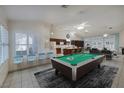Spacious living room featuring a billiards table, seating, and a view into the kitchen at 190 Channel Dr, Henderson, NV 89002