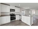 Modern kitchen features stainless steel appliances, white cabinets, and an island with a sink at 2611 Freya Valley St, Las Vegas, NV 89156