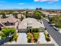 A high-angle shot of a well-maintained home with a three-car garage in a residential neighborhood at 308 Kingsclear Ct, Las Vegas, NV 89145
