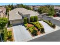 An elevated view of a single-story home with a three-car garage and lush, manicured front yard at 308 Kingsclear Ct, Las Vegas, NV 89145