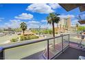 A balcony view featuring palm trees and city views under a bright blue, partly cloudy sky at 353 E Bonneville Ave # 215, Las Vegas, NV 89101