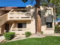 Two-story condo exterior featuring private balconies, desert landscaping and mature trees at 3750 Desert Marina Dr # 37, Laughlin, NV 89029