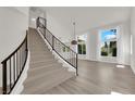 Bright foyer features hardwood floors, an elegant staircase with iron railing and large windows at 3846 Biltmore Bay St, Las Vegas, NV 89147