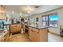Bright and open kitchen with a center island, granite countertops, stainless steel appliances and tile floors at 4075 W Torino Ave, Las Vegas, NV 89139