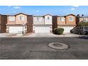 Attractive townhomes with attached garages and colorful facades, creating a welcoming community atmosphere at 4076 Rocky Beach Dr, Las Vegas, NV 89115