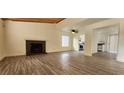 Spacious living room featuring wood-look tile floors, a brick fireplace, and an open layout at 4308 Apex Dr, Las Vegas, NV 89147