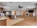 Inviting living space with a kitchen island, fireplace, wood-look flooring, and modern ceiling fans at 4334 Libbiano Ct, Las Vegas, NV 89141