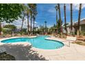 Community pool surrounded by mature trees and ample deck space for lounging at 516 Delfern Ln, Las Vegas, NV 89169