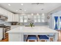 Bright kitchen with white cabinets, a large island with seating, stainless steel appliances and modern lighting at 5642 Breckenridge St, North Las Vegas, NV 89081