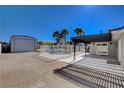 Spacious backyard featuring a gated pool area, covered patio, and large detached garage, perfect for outdoor living at 6117 Foxcroft Ave, Las Vegas, NV 89108