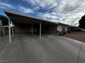 Single-story home featuring a covered carport, a large driveway, and a lawn at 6241 Factor Ave, Las Vegas, NV 89107