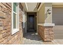 Inviting front entrance featuring a stylish door, stone accents, and manicured landscaping, creating a warm welcome to the home at 6270 Lamont Hills Ave, Las Vegas, NV 89139