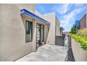 Stylish entrance with a modern blue-accented door, a paved walkway, and attractive landscaping at 668 Falcon Summit Ct, Henderson, NV 89012