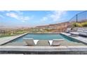 Inviting swimming pool with two chairs for relaxation, offering stunning scenic views of mountains and the city at 668 Falcon Summit Ct, Henderson, NV 89012