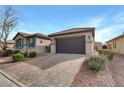 Single-story home with a paver driveway, two-car garage, and desert landscaping at 6814 Willowcroft St, Las Vegas, NV 89149