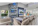 Bright living room with a vaulted ceiling, fireplace, media center, and an open layout into the kitchen at 6925 Emerald Springs Ln, Las Vegas, NV 89113