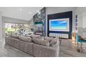 Modern living room with a vaulted ceiling, a fireplace, a television, and a large sectional couch at 6925 Emerald Springs Ln, Las Vegas, NV 89113