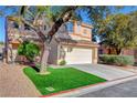 Inviting two-story home featuring a manicured lawn, mature trees, and a convenient two-car garage at 7721 Sour Gum Ct, Las Vegas, NV 89131