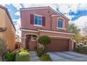 Two-story home features a two-car garage, manicured landscaping, a covered front entry, and close proximity to other homes at 7769 Peaceful Trellis Dr, Las Vegas, NV 89179