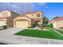 A well-maintained, two-story home with a red tile roof, a green lawn and two-car garage at 7916 Nesting Pine Pl, Las Vegas, NV 89143