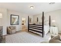 Cozy bedroom featuring a four-poster bed, neutral decor, and an ensuite bathroom for added privacy at 8316 Imperial Lakes St, Las Vegas, NV 89131